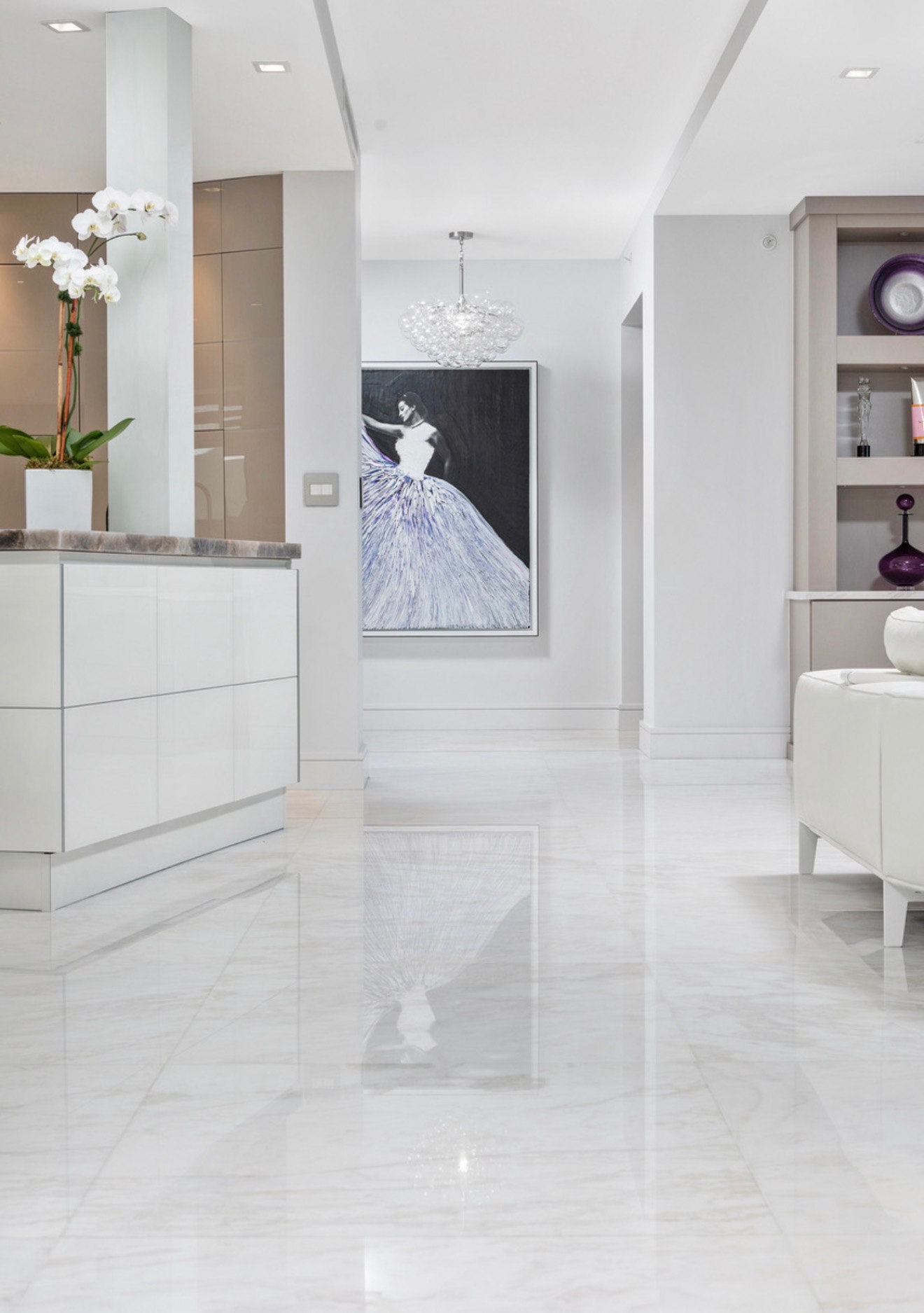 Polished marble interior with custom cabinetry, artwork, and sculptural lighting