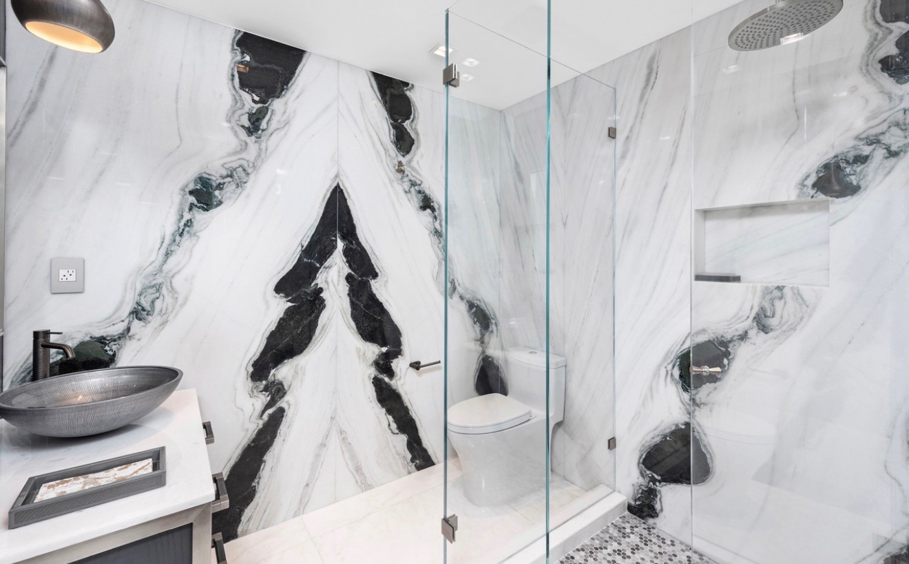 Luxury glass shower wrapped in book-matched black and white marble
